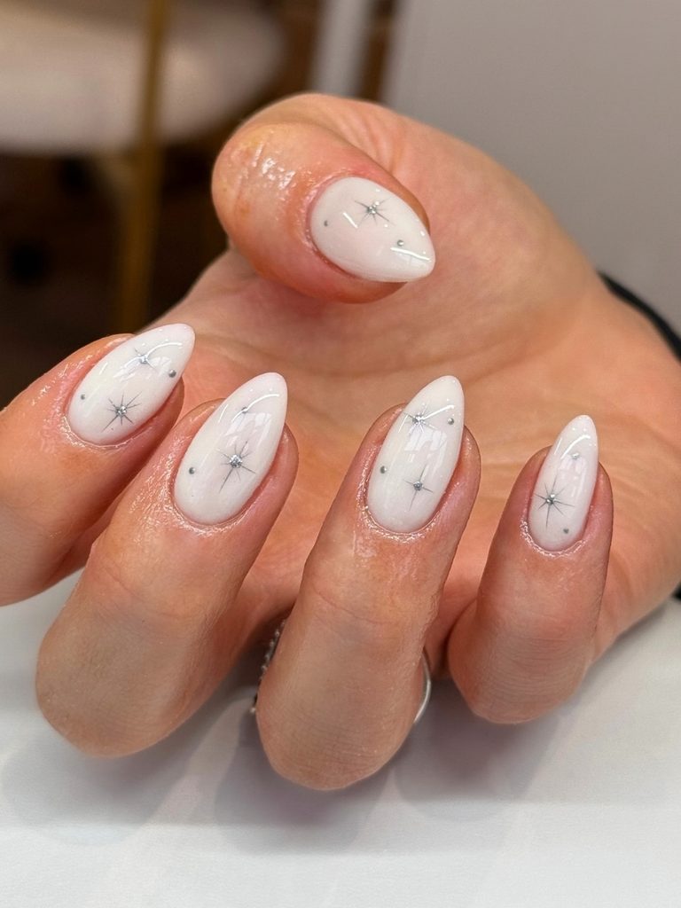 White winter nails with silver starburst nail art