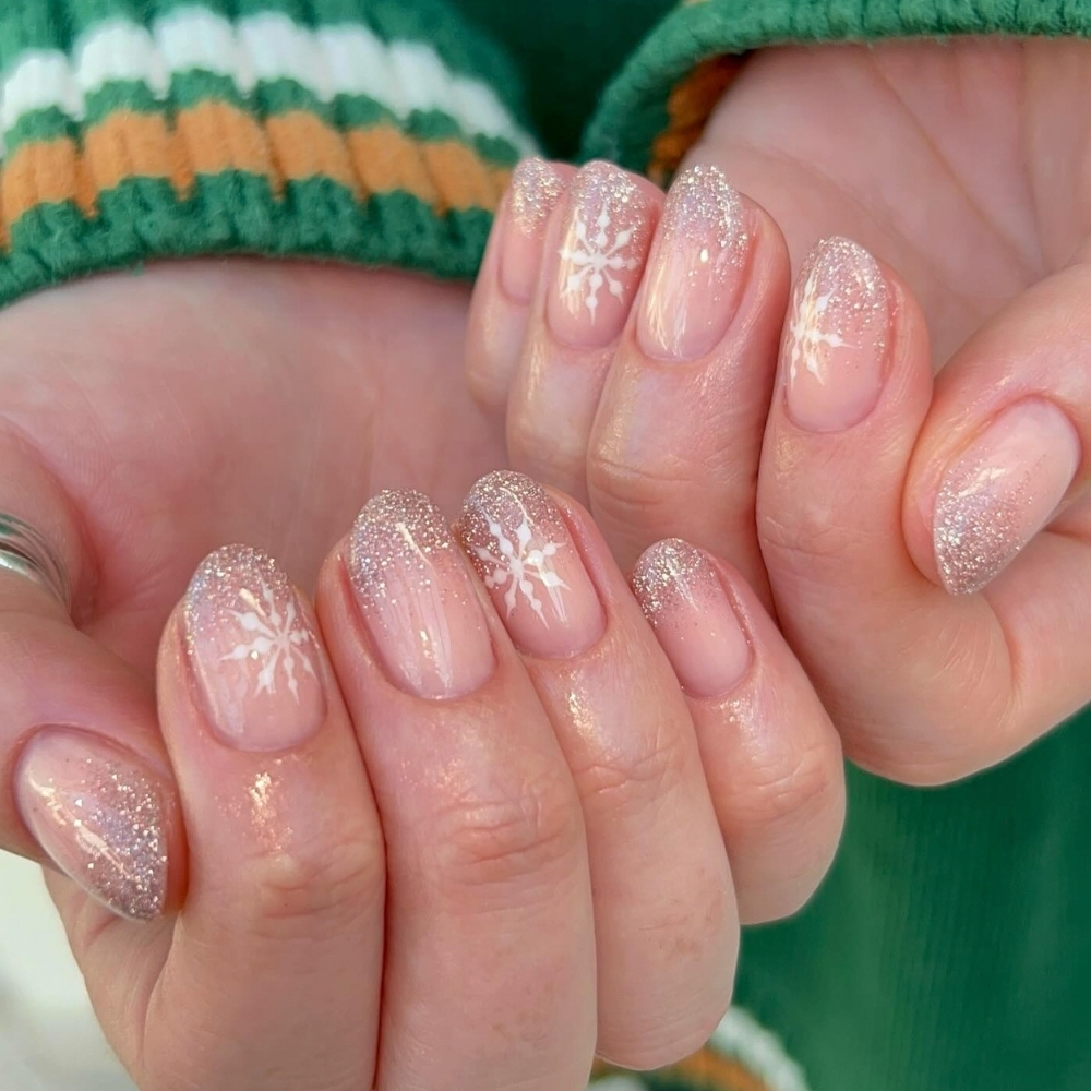 Short winter nails with gold glitter and white snowflakes