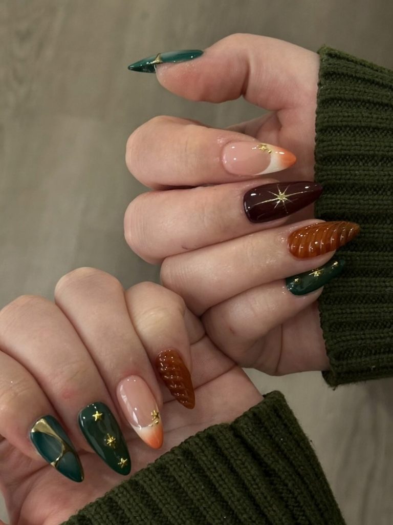 Dark green and rust winter nail ideas with gold stars