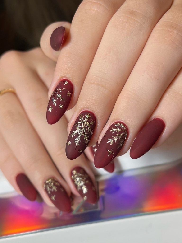 Matte burgundy snowflake nails with gold foil