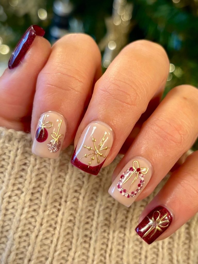 Short burgundy holiday nails with ornaments and gold bows