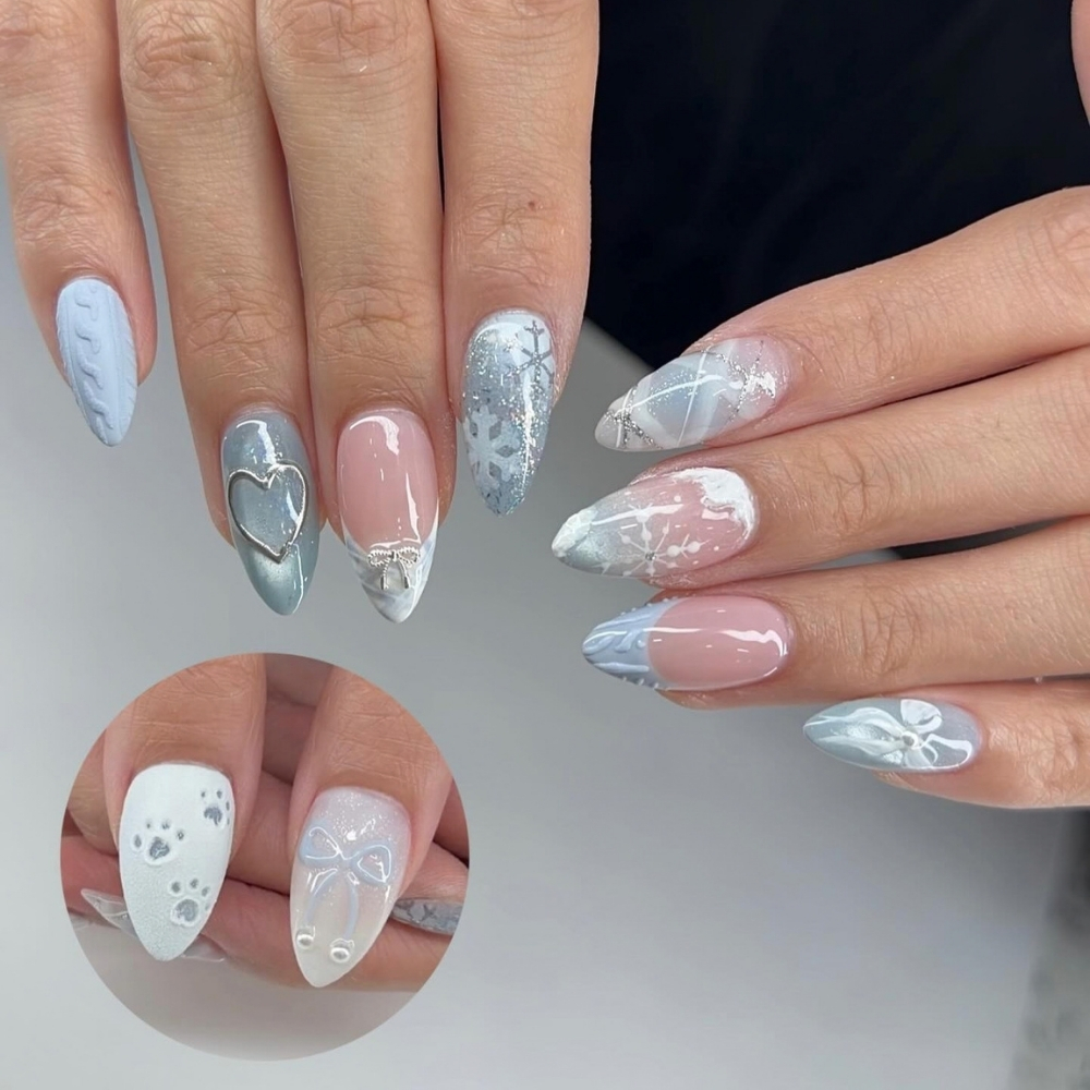 Pale blue winter nail art with a chrome heart and bows