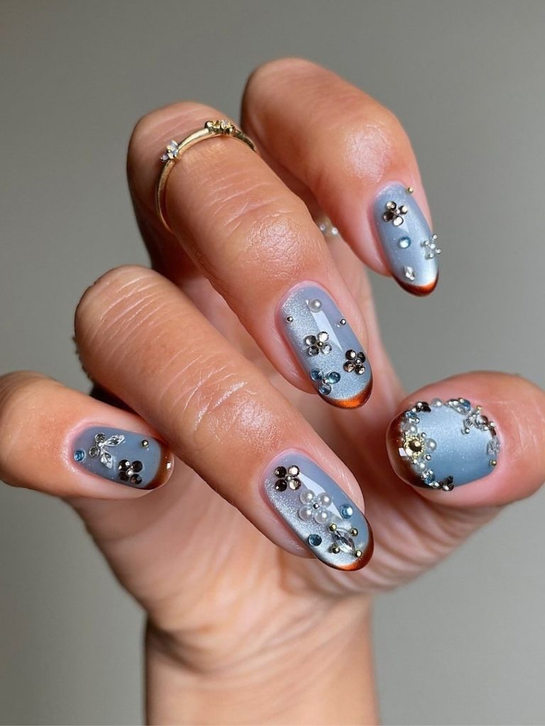 Blue winter nail art with cat-eye shine, crystals and burgundy tips